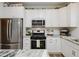 Modern kitchen boasts stainless steel appliances, white cabinets, and granite counters with a sleek backsplash at 808 Trinity Park Dr, Wake Forest, NC 27587