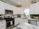 Updated kitchen featuring stainless appliances, white cabinets, granite countertops, and modern lighting fixtures at 808 Trinity Park Dr, Wake Forest, NC 27587