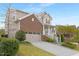 Charming two-story home featuring a brick facade, two-car garage, and a welcoming front porch with manicured landscaping at 844 Cozy Oak Ave, Cary, NC 27519