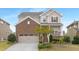 Charming two-story home with a brick facade, attached garage, and professionally landscaped front yard at 844 Cozy Oak Ave, Cary, NC 27519