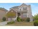 Charming two-story home featuring a brick facade, two-car garage, and a welcoming front porch with manicured landscaping at 844 Cozy Oak Ave, Cary, NC 27519
