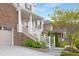 Inviting home entrance featuring a covered porch, white railings, brick accents, and landscaped garden at 844 Cozy Oak Ave, Cary, NC 27519