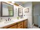 Double vanity bathroom features modern light fixtures and stylish wood grain cabinets at 8517 Falkirk Ridge Ct, Wake Forest, NC 27587