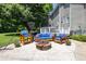Inviting backyard patio with comfortable blue cushioned seating around a charming stone fire pit at 8517 Falkirk Ridge Ct, Wake Forest, NC 27587