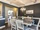Dining room featuring coffered ceilings, dark gray accent walls, and views into the kitchen area at 90 Heathgreen Dr, Clayton, NC 27527