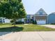 Charming two-story home featuring a stone accented facade, well-manicured lawn, and a double car garage at 90 Heathgreen Dr, Clayton, NC 27527