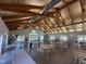 Spacious event space with vaulted ceilings, wood beams, and tables with chairs at 90 Heathgreen Dr, Clayton, NC 27527