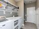 Efficient laundry room with shelving, storage baskets, and modern washer/dryer units at 90 Heathgreen Dr, Clayton, NC 27527