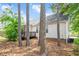 Secluded backyard view with mature trees, pine straw ground cover, and a small deck at 901 N Taylor St, Wake Forest, NC 27587