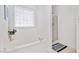 Bright bathroom with a large tub, a shower, and a window at 901 N Taylor St, Wake Forest, NC 27587