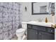 Well-lit bathroom features a shower with patterned curtain, a vanity, and a mirror at 901 N Taylor St, Wake Forest, NC 27587