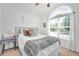 Bright bedroom features neutral colors, a large arched window and comfortable furnishings at 901 N Taylor St, Wake Forest, NC 27587