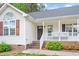Welcoming front porch with white railings, brick steps and colorful landscaping at 901 N Taylor St, Wake Forest, NC 27587