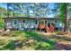 Exterior view of a home featuring a wood deck overlooking a spacious, well-maintained backyard at 9220 Old Cascade Dr, Garner, NC 27529