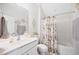 Bright bathroom with a sink and vanity, decorative artwork, and a bathtub with a shower curtain at 94 Two Creeks, Chapel Hill, NC 27517