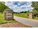 Stone signage at the community entrance, featuring beautiful landscaping and a welcoming drive at 94 Two Creeks, Chapel Hill, NC 27517