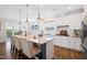Bright kitchen featuring stainless steel appliances, a large island with seating, and sliding door to patio at 94 Two Creeks, Chapel Hill, NC 27517