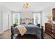 Comfortable main bedroom featuring a wrought iron bed, a chandelier, and lots of natural light at 94 Two Creeks, Chapel Hill, NC 27517