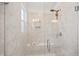 Bright bathroom shower featuring white marble-styled tile, a built-in seat, and a hand-held shower head at 94 Two Creeks, Chapel Hill, NC 27517