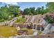 Scenic waterfall cascading into a serene pond, creating a tranquil and picturesque community amenity at 94 Two Creeks, Chapel Hill, NC 27517