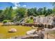 Picturesque tiered waterfall flowing into a tranquil pond, enhanced by rocks and lush greenery at 94 Two Creeks, Chapel Hill, NC 27517