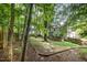 Wooded backyard featuring mature trees and grass. Deck can be seen attached to the back of the house at 9408 Bells Valley Dr, Raleigh, NC 27617