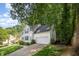 White two-story home with an attached garage and lush green lawn, surrounded by mature trees at 9408 Bells Valley Dr, Raleigh, NC 27617