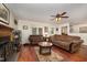 Cozy living room featuring plush brown sofas, hardwood floors, and a decorative fireplace at 9408 Bells Valley Dr, Raleigh, NC 27617