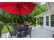 Outdoor patio with red umbrella, table, seating, and grill at 9517 Candor Oaks Dr, Raleigh, NC 27615
