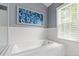 Bright bathroom featuring a soaking tub with subway tile surround and natural light from the window at 9517 Candor Oaks Dr, Raleigh, NC 27615