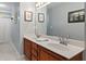 Bathroom featuring double sinks with wood vanity and large mirror at 9517 Candor Oaks Dr, Raleigh, NC 27615