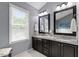 Bathroom featuring double sinks with granite countertop vanity and modern fixtures at 9517 Candor Oaks Dr, Raleigh, NC 27615