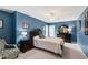 This primary bedroom is painted blue and has a decorative chair and carpeted floor at 9517 Candor Oaks Dr, Raleigh, NC 27615