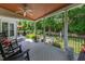 Back deck offers wooded views, ceiling fan, and black rocking chairs at 9517 Candor Oaks Dr, Raleigh, NC 27615