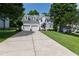 Two-story home with a large driveway and manicured lawn, set against a backdrop of mature trees at 9517 Candor Oaks Dr, Raleigh, NC 27615