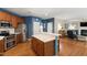 Open kitchen features stainless appliances, wood cabinets, breakfast bar, and access to living room at 9517 Candor Oaks Dr, Raleigh, NC 27615