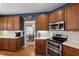 This kitchen features wooden cabinets, tile backsplash, and stainless steel appliances at 9517 Candor Oaks Dr, Raleigh, NC 27615