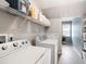 Bright laundry room with modern appliances, shelving, and tile flooring at 9517 Candor Oaks Dr, Raleigh, NC 27615