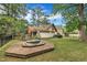 Exterior view of the home showcasing the backyard deck, in-ground spa, and trees at 1003 W Divine St, Dunn, NC 28334