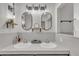 Bright bathroom featuring dual sinks, modern lighting, and neutral tiling at 1003 W Divine St, Dunn, NC 28334
