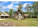 Quaint home with stone accents, large windows, and a well-manicured lawn, framed by mature trees at 1003 W Divine St, Dunn, NC 28334