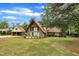 Landscaped front yard with an A-frame home featuring stone and wood accents, and a detached garage at 1003 W Divine St, Dunn, NC 28334