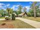 Exterior view of a home on a tree-lined lot, with a long driveway and garage at 1003 W Divine St, Dunn, NC 28334