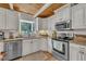 Bright kitchen features white cabinets, stainless appliances, granite counters, and wood ceiling at 1003 W Divine St, Dunn, NC 28334