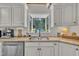 Kitchen features white cabinets, granite counters, stainless dishwasher, and a view from the window at 1003 W Divine St, Dunn, NC 28334