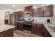 Well-equipped kitchen featuring stainless steel appliances, granite countertops, and dark wood cabinets at 1012 Ringhill Bluff Dr, Durham, NC 27704