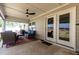 Covered patio boasts seating, a ceiling fan, and glass doors to the home's interior at 1012 Ringhill Bluff Dr, Durham, NC 27704