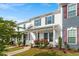 Three townhomes with manicured lawns and covered front porches, with red and green door/shutter accents at 1027 Myers Point Dr, Morrisville, NC 27560