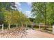This outdoor wood deck features white railings, overlooking the home's treed backyard at 105 Hiddenwood Ct, Garner, NC 27529
