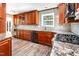 Open kitchen with wood cabinets, granite countertops, and modern stainless steel appliances at 105 Hiddenwood Ct, Garner, NC 27529